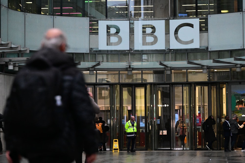 A man walks in front of the BBC headquarters.