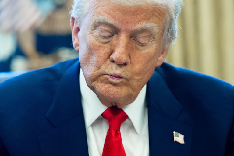 Donald Trump purses his lips while sitting in the Oval Office