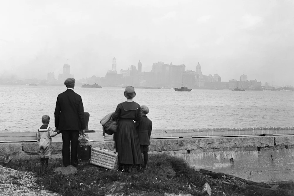 An immigrant family views the New York skyline from the dock at Ellis Island in 1925.