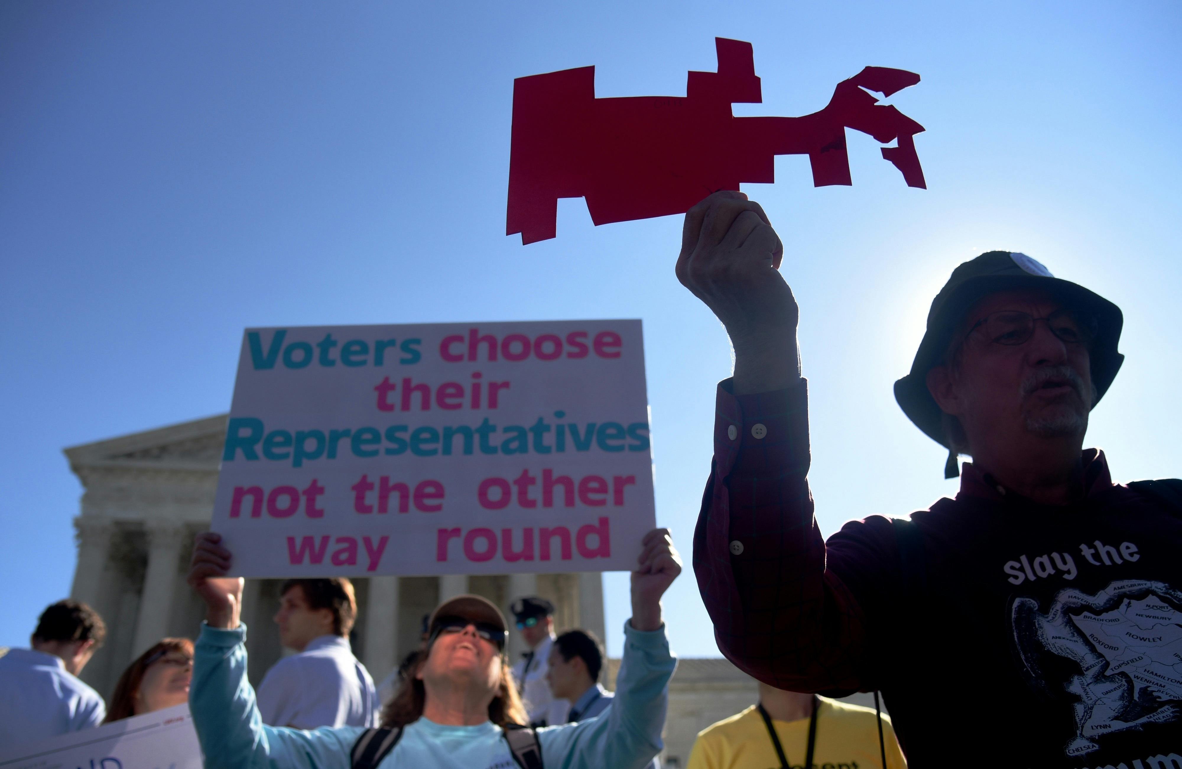 A demonstrator holds up a cutout of a gerrymandered district as protestors gather outside the Supreme Court. The high court has been resistant to the entreaties of reformers.