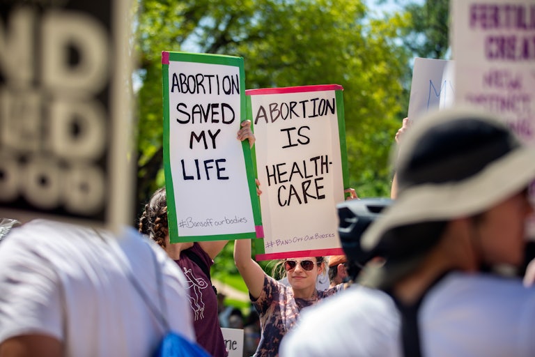 People hold up pro-abortion rights protest signs