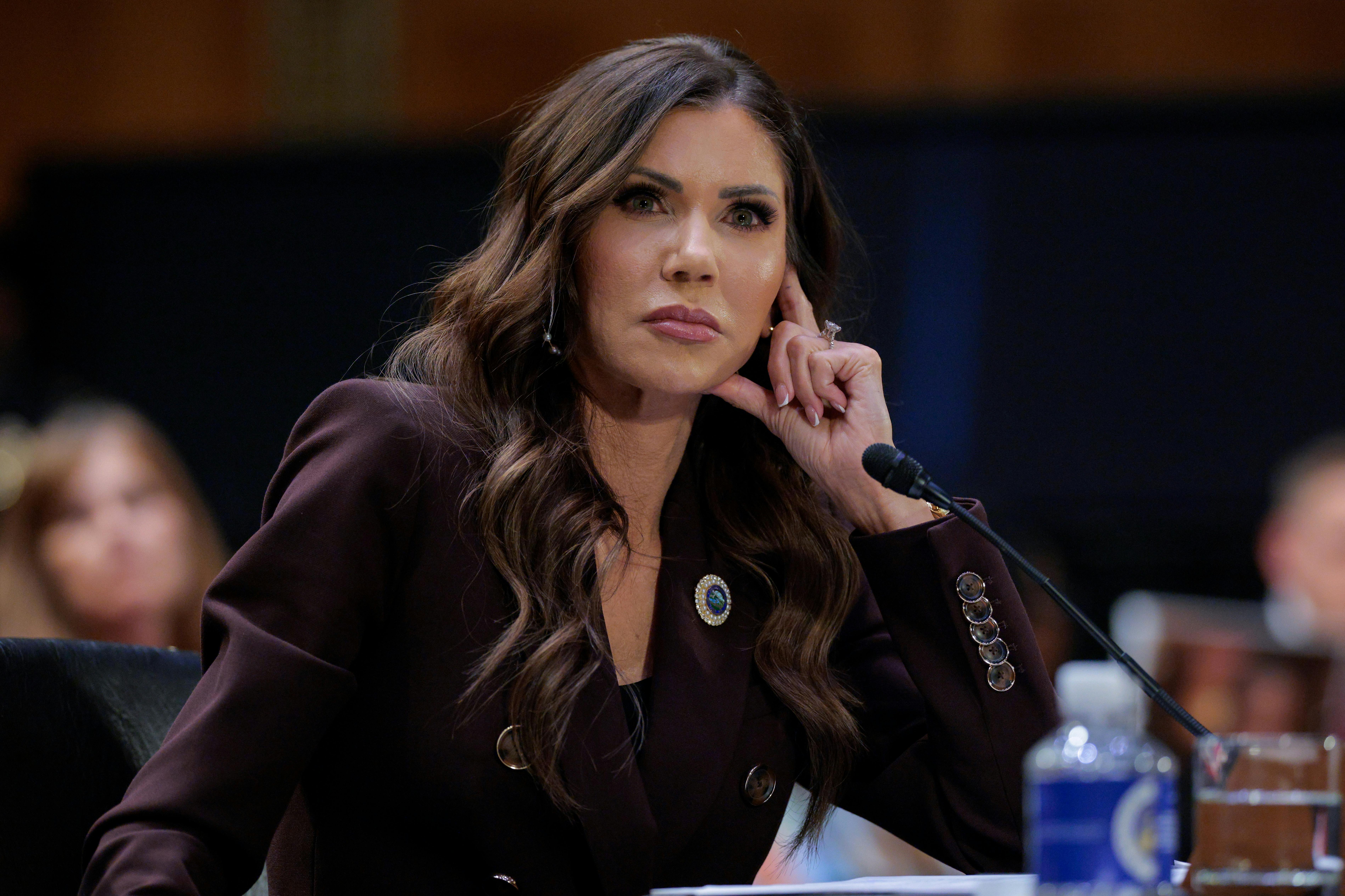 DHS Secretary Kristi Noem rests her head on her hand while testifying to Congress.