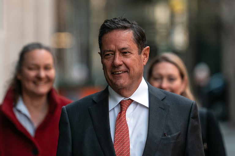 Former Barclays CEO Jess Staley walks outside, with two women behind him.