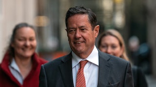 Former Barclays CEO Jess Staley walks outside, with two women behind him.