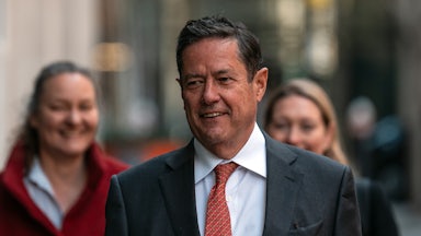 Former Barclays CEO Jess Staley walks outside, with two women behind him.