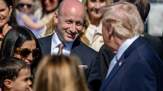 Stephen Miller speaks with Donald Trump in a crowd fo people