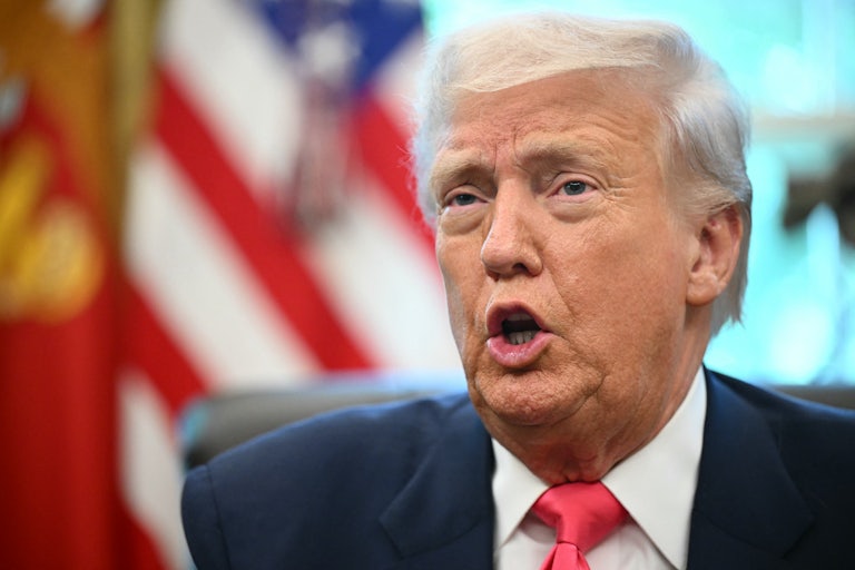 Donald Trump speaks while sitting at his desk in the Oval Office