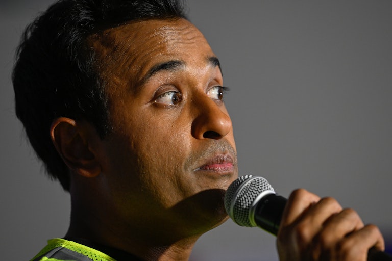 Vivek Ramaswamy raises his eyebrows and holds a microphone up to his face