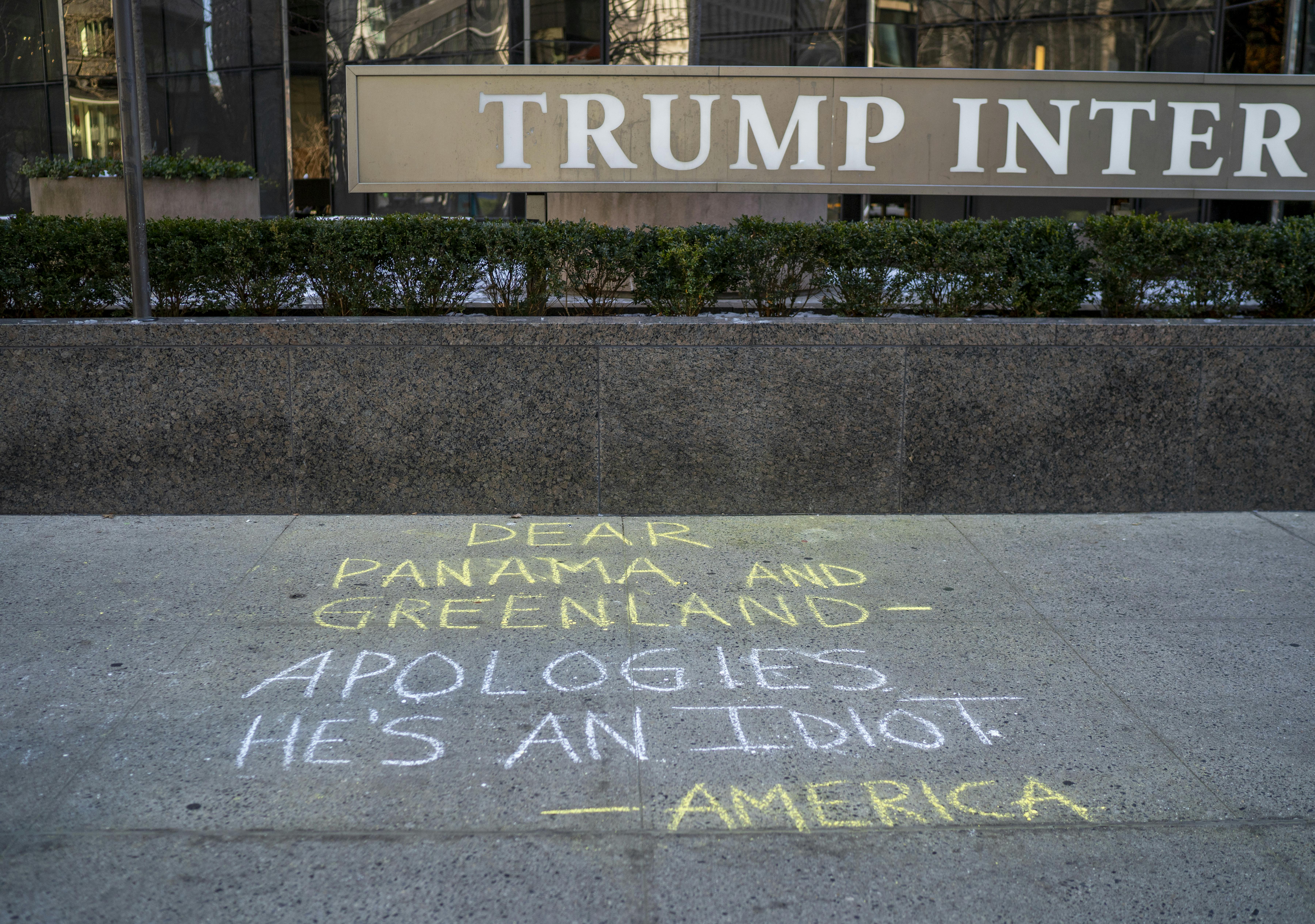 Graffiti is drawn on the sidewalk at the Trump International Hotel referencing President-elect Donald Trump's recent comments that the U.S. should own and control Greenland and the Panama Canal.