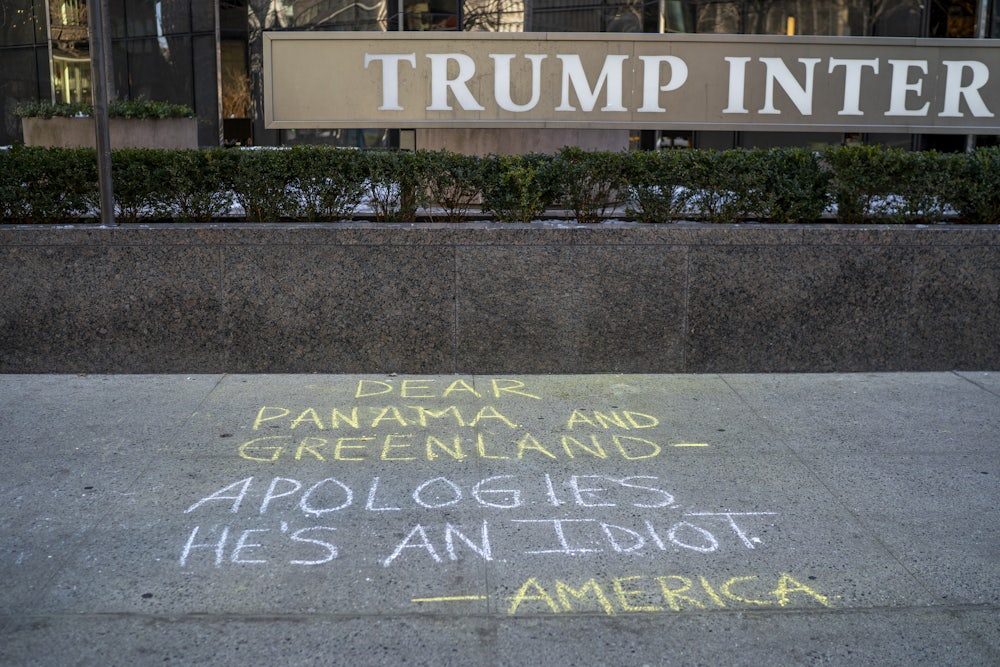 Graffiti is drawn on the sidewalk at the Trump International Hotel referencing President-elect Donald Trump's recent comments that the U.S. should own and control Greenland and the Panama Canal.