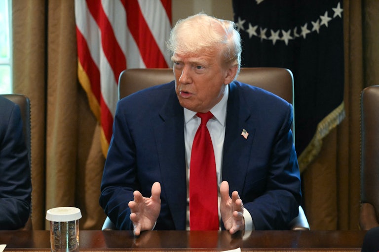 Donald Trump gestures and speaks while sitting in his Cabinet meeting
