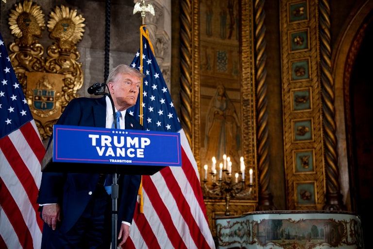 Donald Trump leans over while standing at a podium