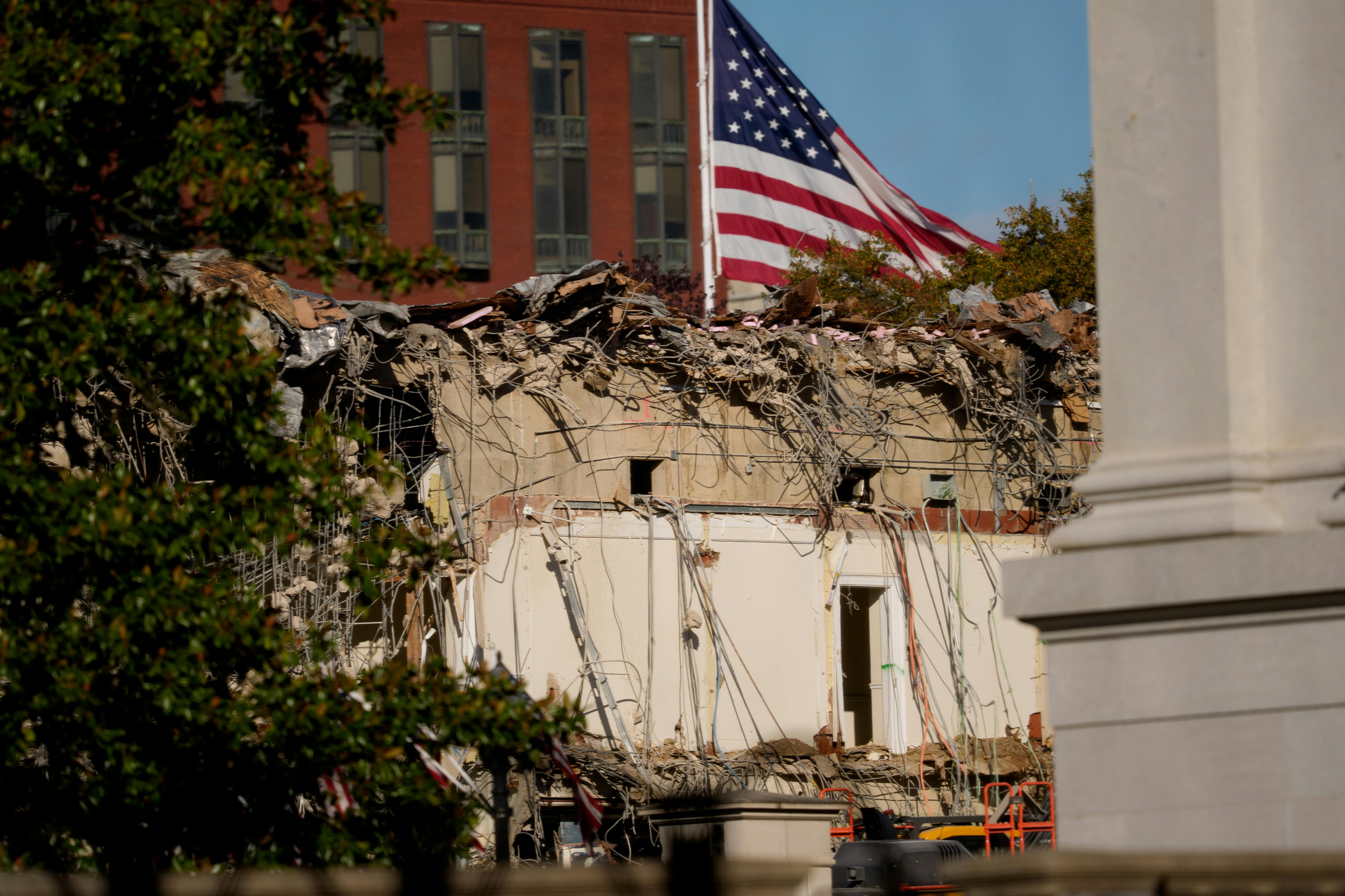 A U.S. flag flies behind the demolished East Wing of the White House.