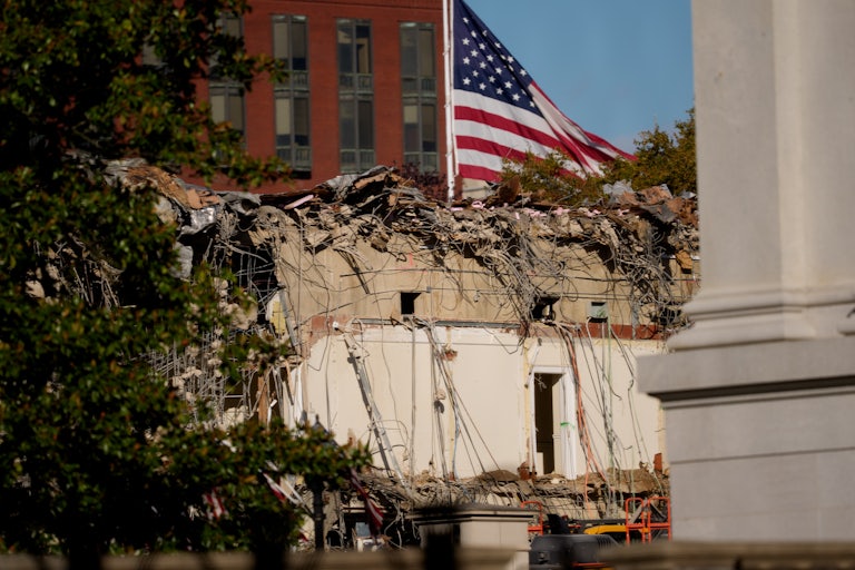A U.S. flag flies behind the demolished East Wing of the White House.
