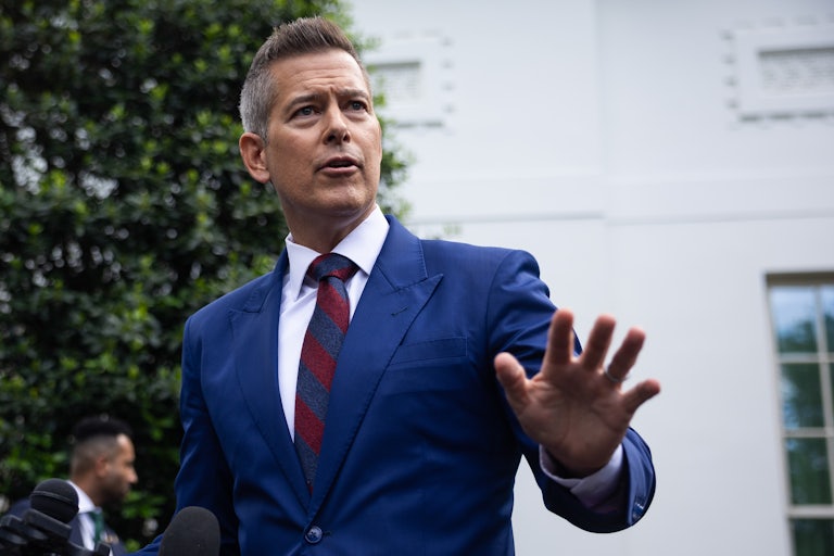 Transportation Secretary Sean Duffy raises a hand and furrows his brows.