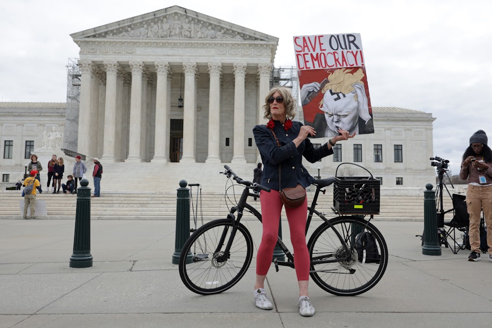Local resident Nicky Sundt holds a sign that read “Save Our Democracy” in front of the Supreme Court, which unanimously ruled to keep former U.S. President Donald Trump on the Colorado ballot.
