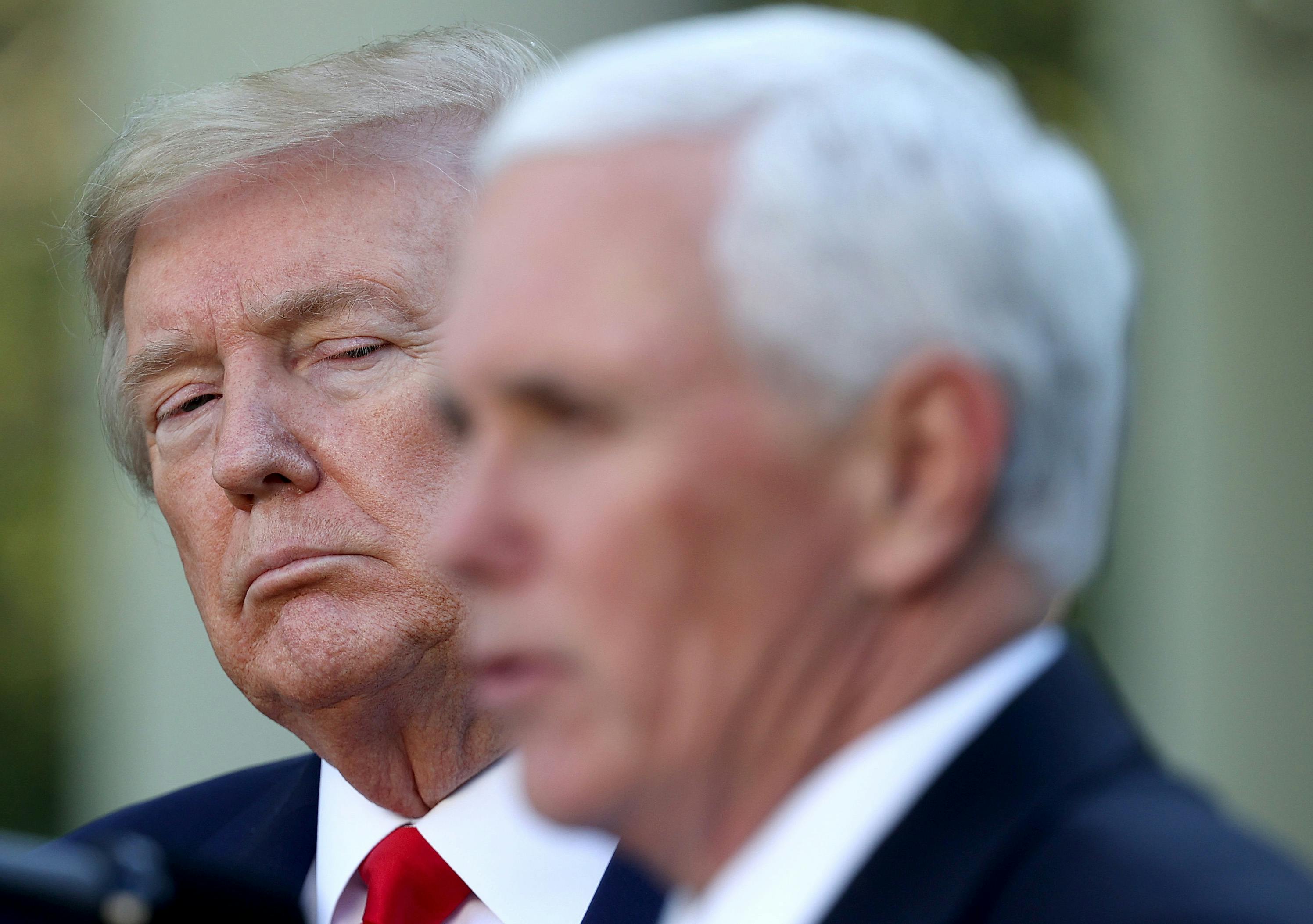 Mike Pence's blurry head appears in the foreground as President Donald Trump looks on from behind.