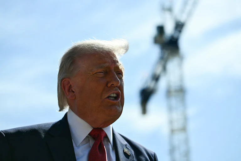 Donald Trump speaks in front of a crane