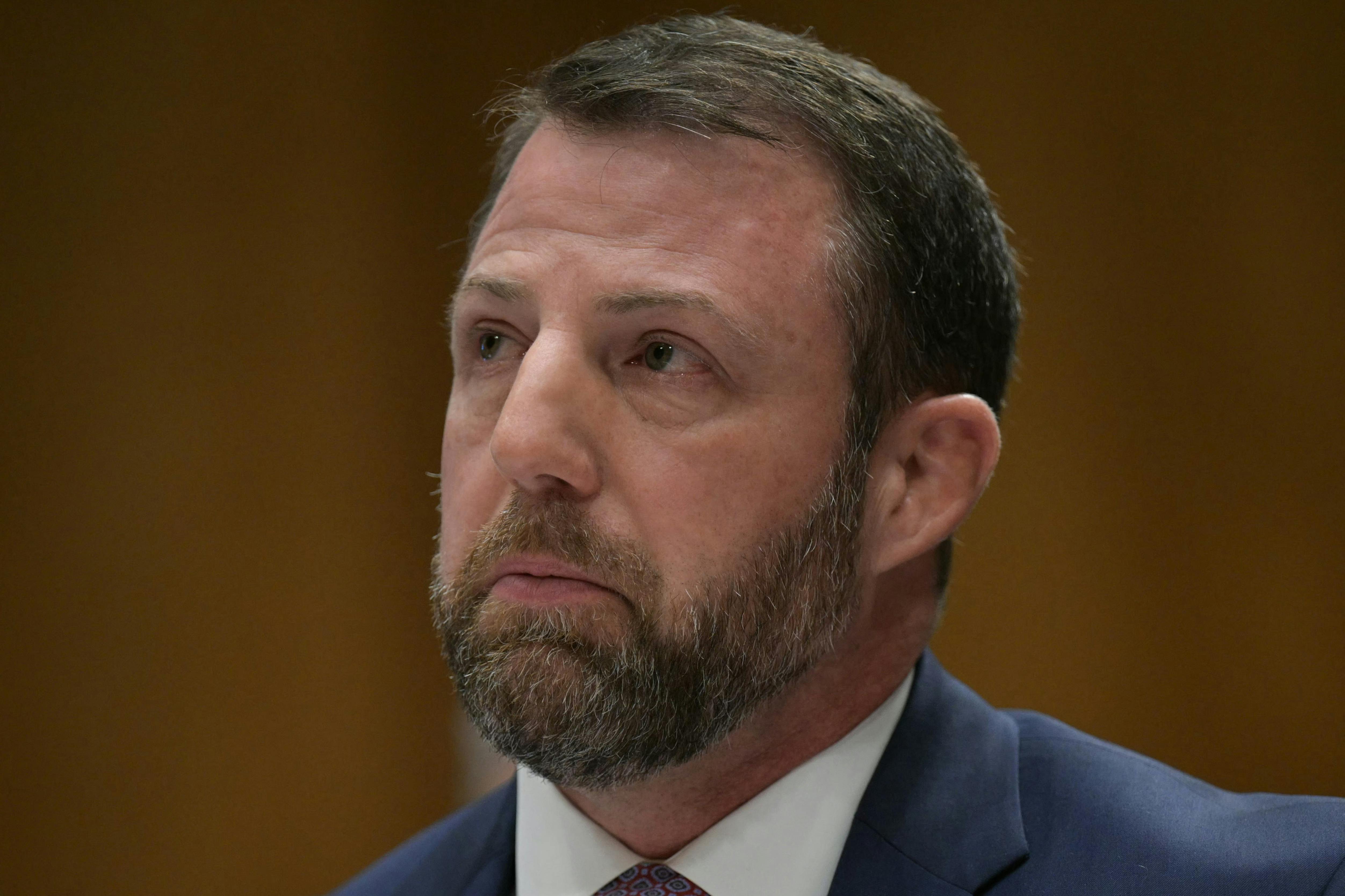 Senator Markwayne Mullin looks up while sitting in his Senate committee confirmation hearing for Homeland Security secretary.