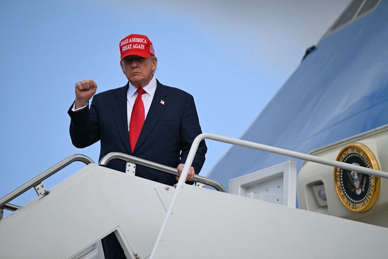 Donald Trump raises his fist while exiting Air Force One