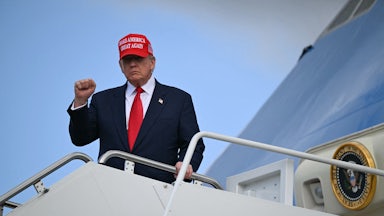 Donald Trump raises his fist while exiting Air Force One