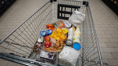 Grocery cart with potatoes, cream cheese, carrots, and more
