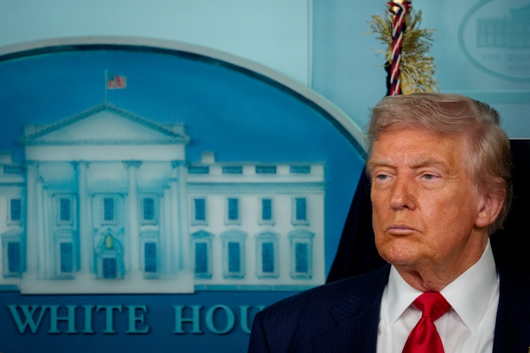 Donald Trump frowns while standing in the White House press briefing room
