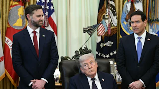 President Donald Trump sits at his desk in the Oval Office, while Vice President JD Vance and Secretary of State Marco Rubio stand behind him.