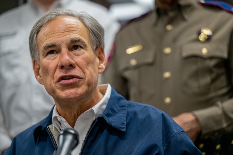Greg Abbott in foreground, law enforcement behind him