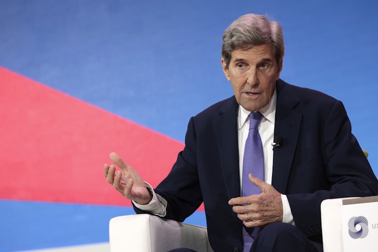 John Kerry gesticulates while speaking, seated.
