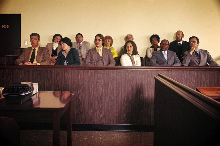 Twelve jurors sit in a jury box in the 1970s.