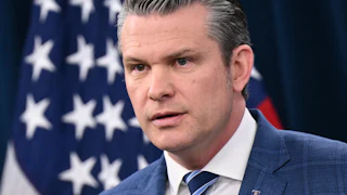 Pete Hegseth stares while answering media questions
