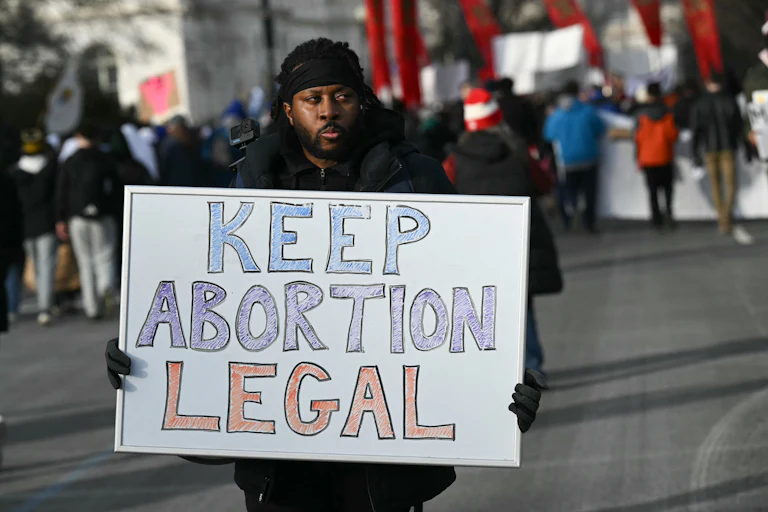 A person holds a sign that says, "Keep abortion legal" during a protest