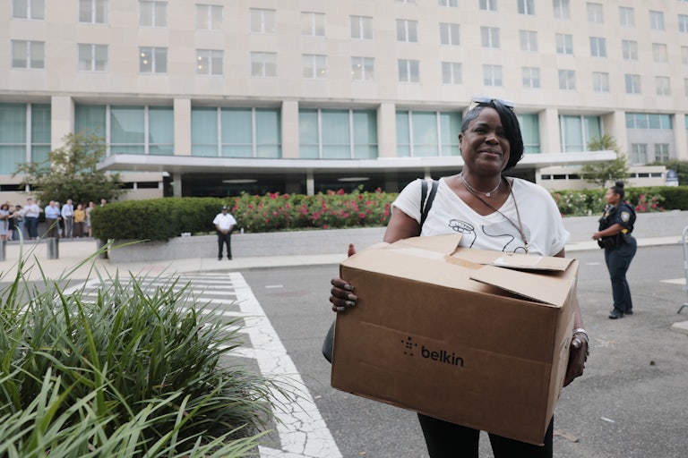 Former U.S. State Department employees carry boxes as they walk out of the Harry S. Truman Federal Building in July.