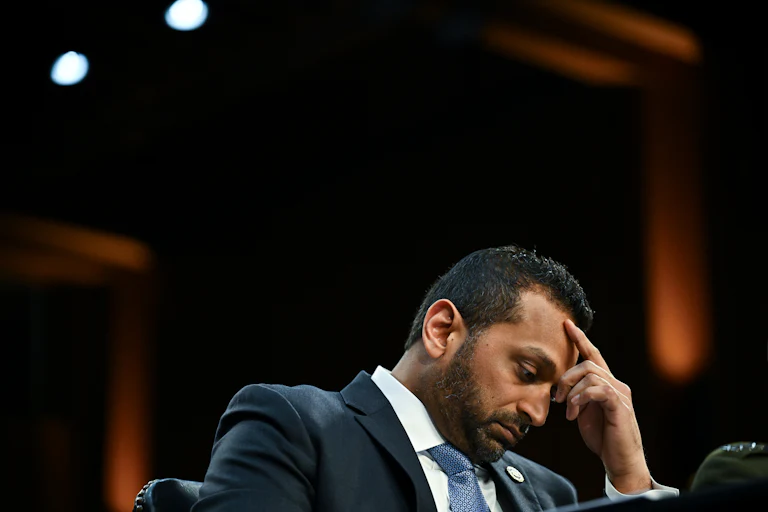 FBI Director Kash Patel leans forward and puts his head in his hand during a congressional hearing.