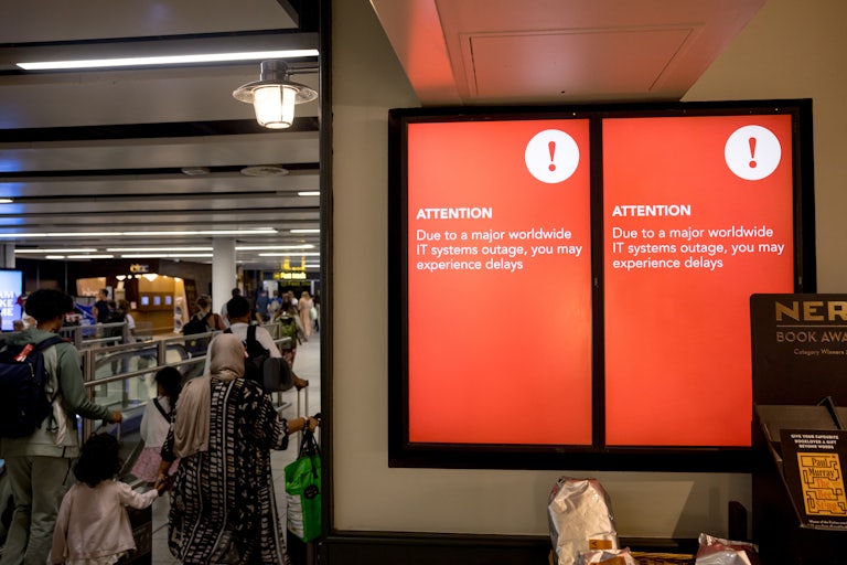 A screen displays an announcement on possible travel delays due to a global IT outage