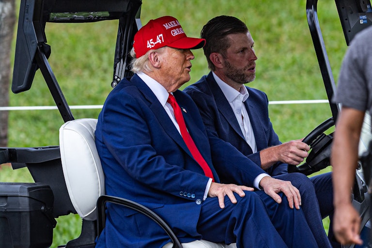 Donald Trump and his son Eric ride in a golf cart at their Doral golf club