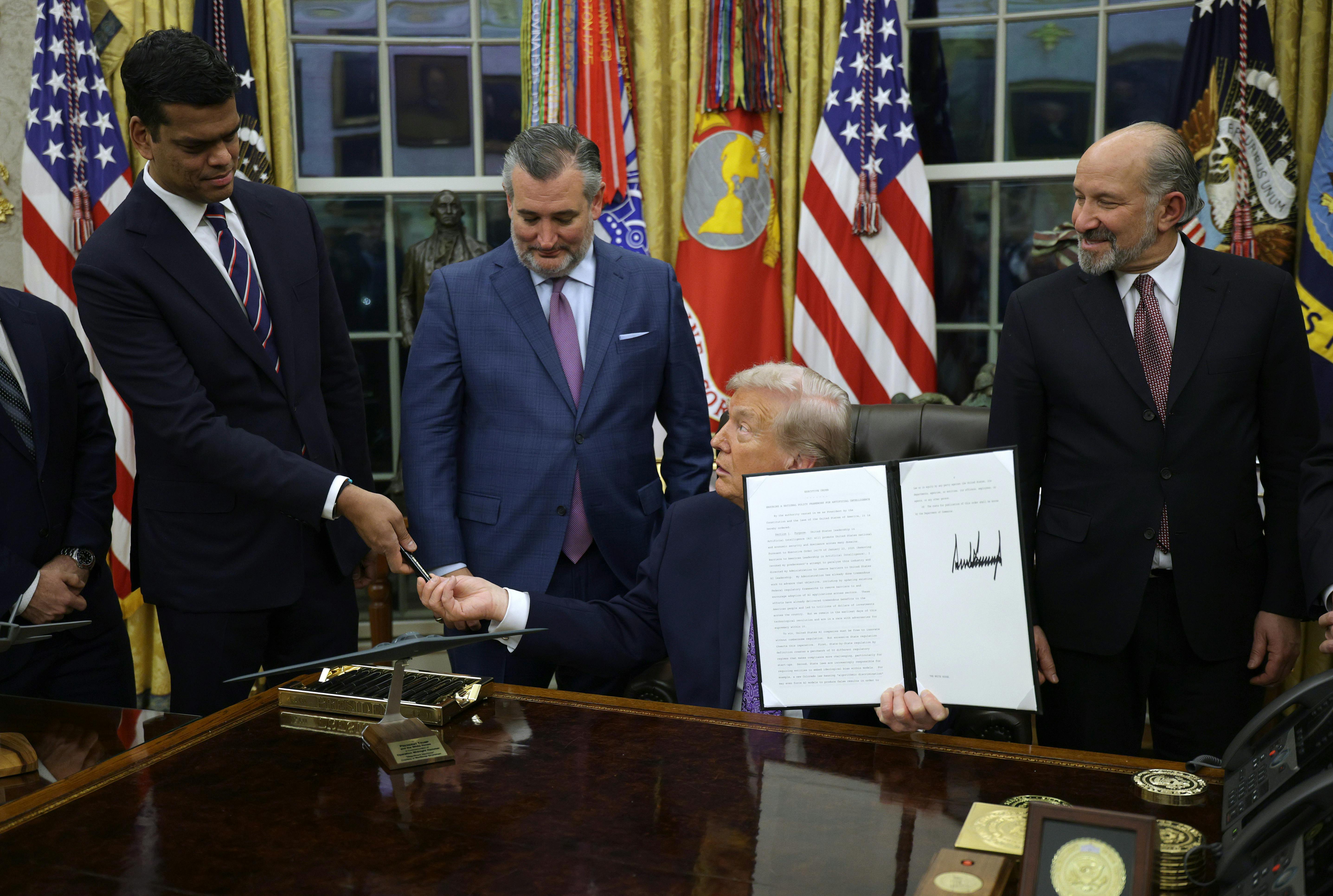 Donald Trump signs an executive order in the Oval Office. 