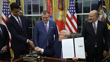 Donald Trump signs an executive order in the Oval Office.