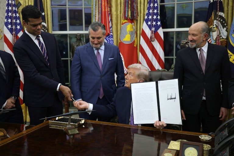 Donald Trump signs an executive order in the Oval Office.
