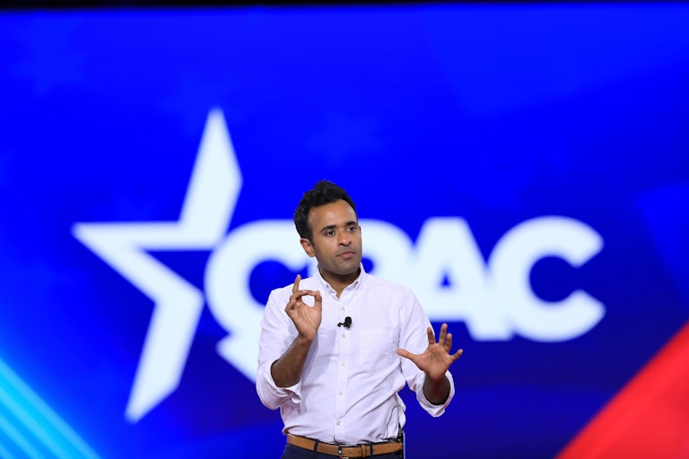 Vivek Ramaswamy speaks at CPAC (the giant letters are behind him) and makes hand gestures