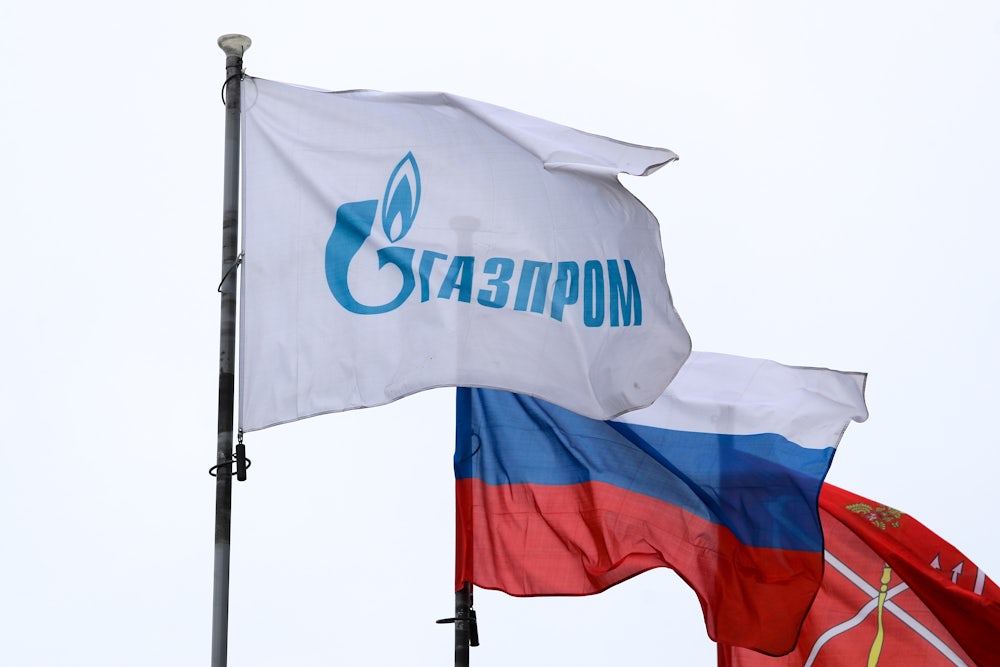 A flag with the logo of Gazprom, one of Russia's largest state-owned energy companies, flies next to the banner of the Russian Federation.