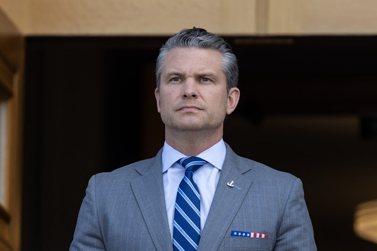 Defense Secretary Pete Hegseth stands