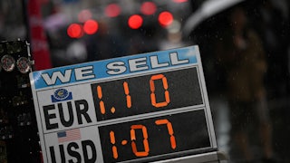 A board displaying the price of Euros and U.S. dollars against British pounds