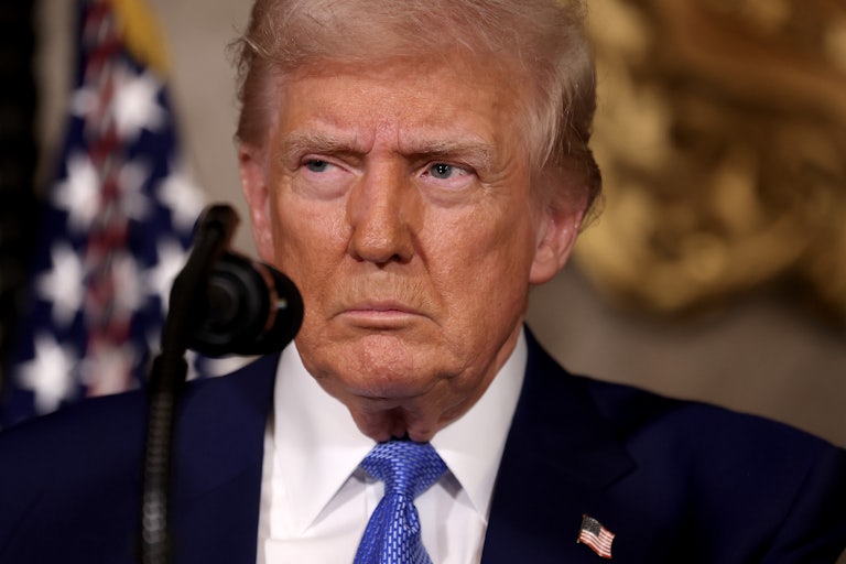 donald Trump squints behind a microphone