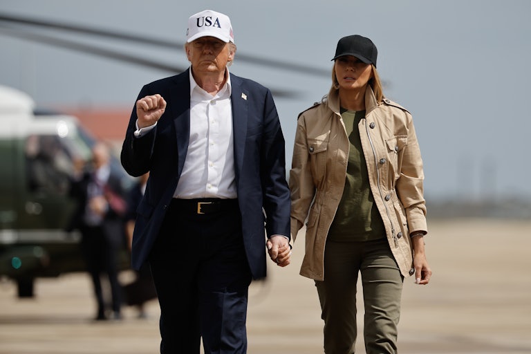 President Trump and the First Lady stand on a tarmac.