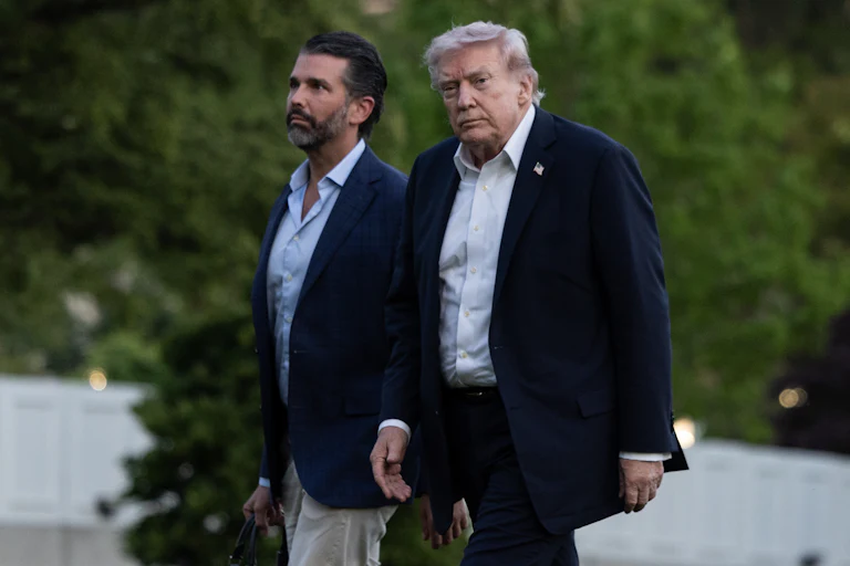 Donald Trump Jr. and Donald Trump walk next to each other outside the White House
