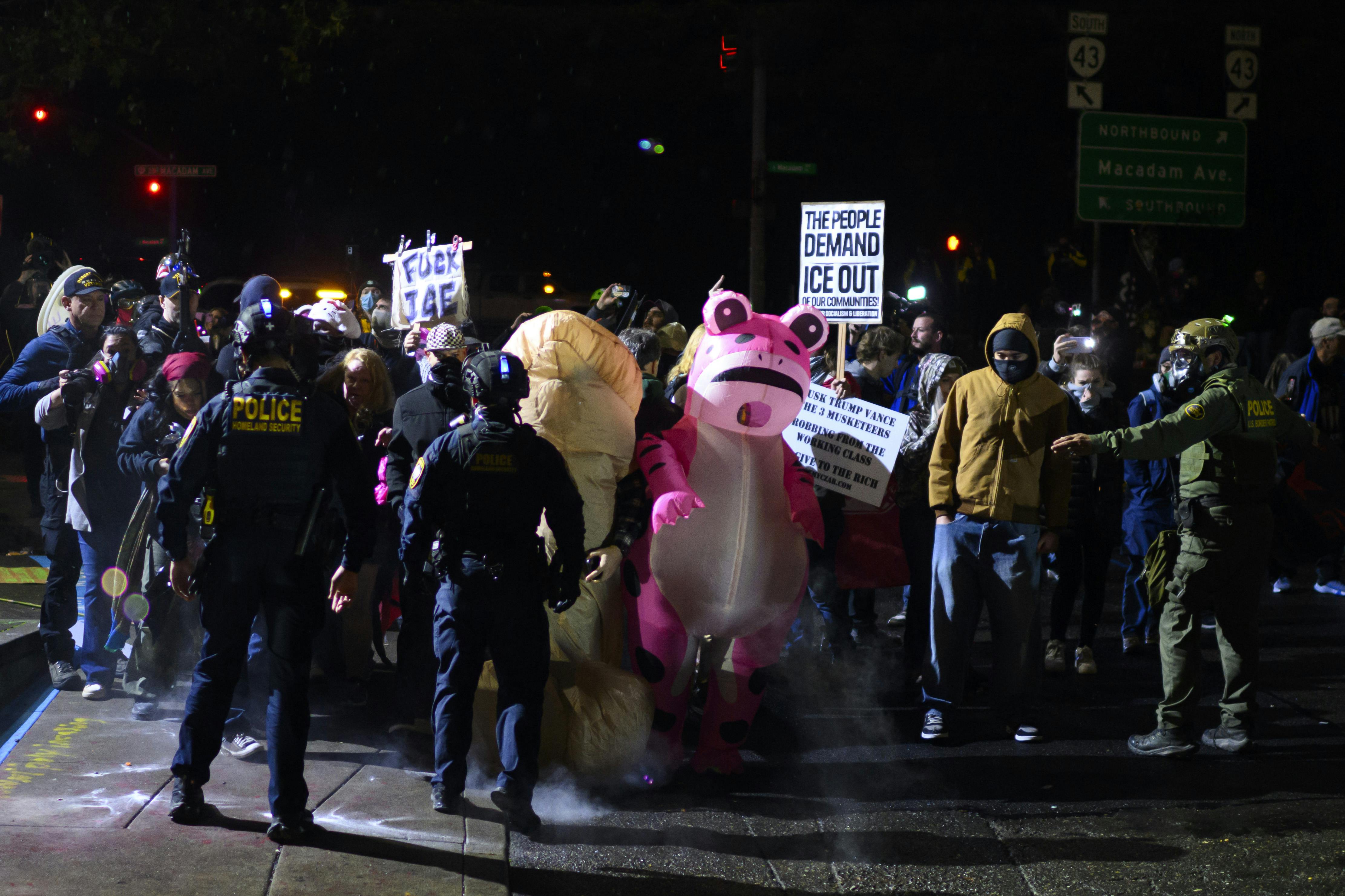 Protesters stand in front of federal officers in Portland, Oregon