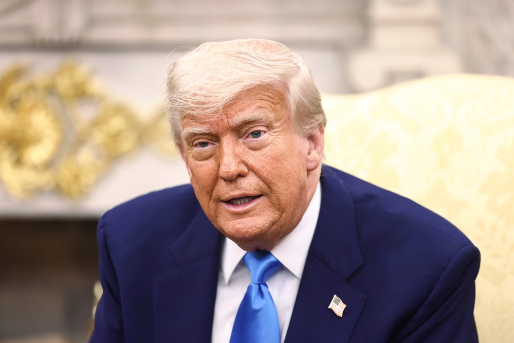 Donald Trump sits in the Oval Office