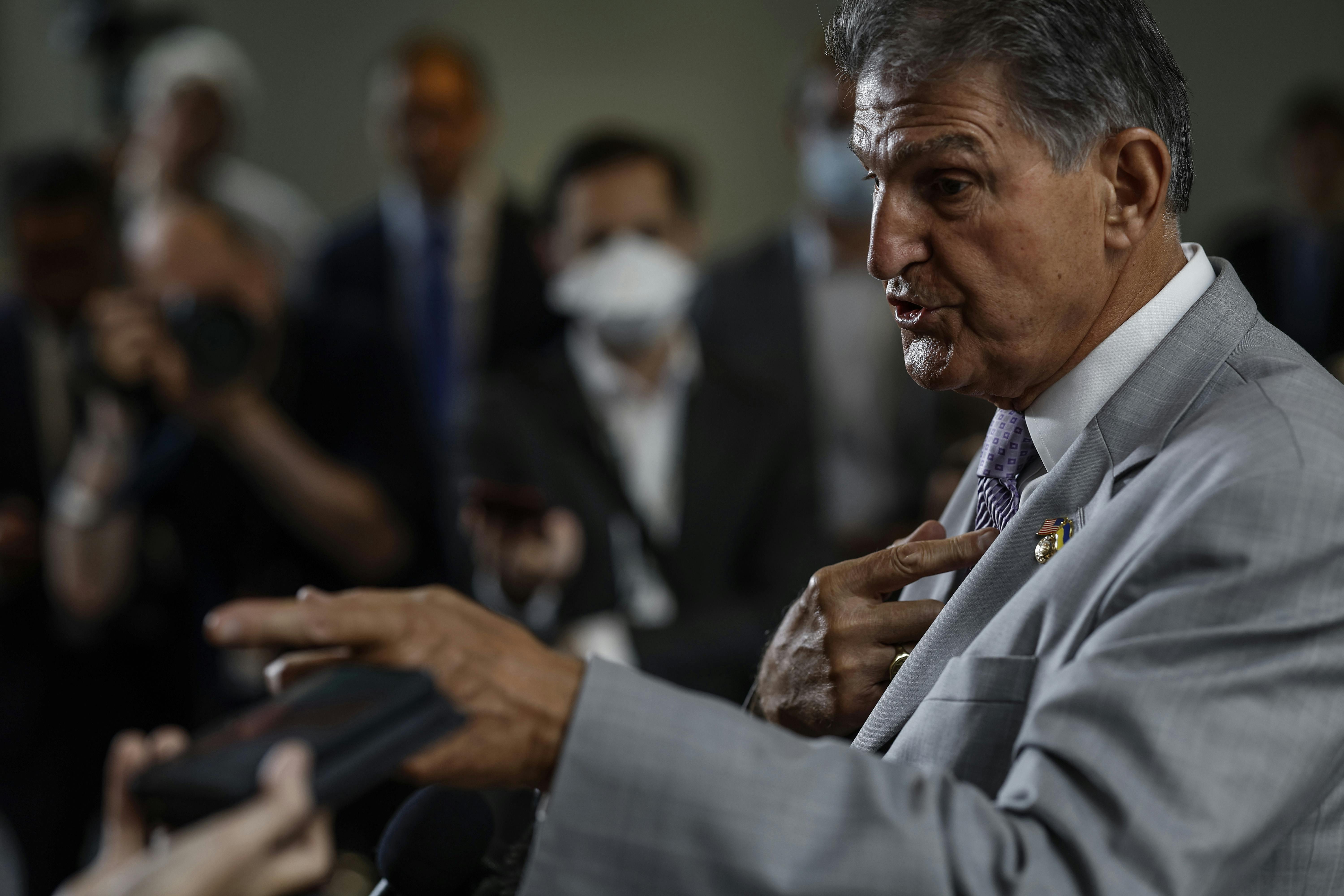 Senator Manchin gesticulates while speaking.